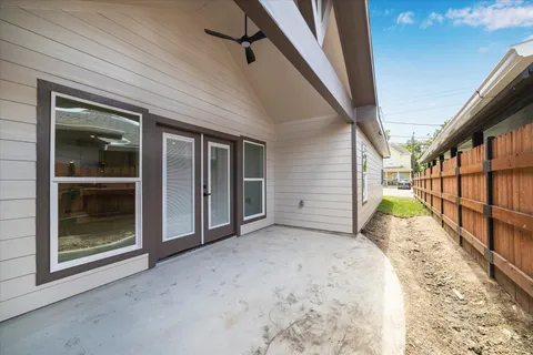 a view of empty room with wooden floor and next to a window