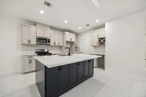 a kitchen with kitchen island a sink appliances and cabinets