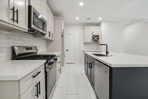 a kitchen with stainless steel appliances a sink stove top oven and cabinets