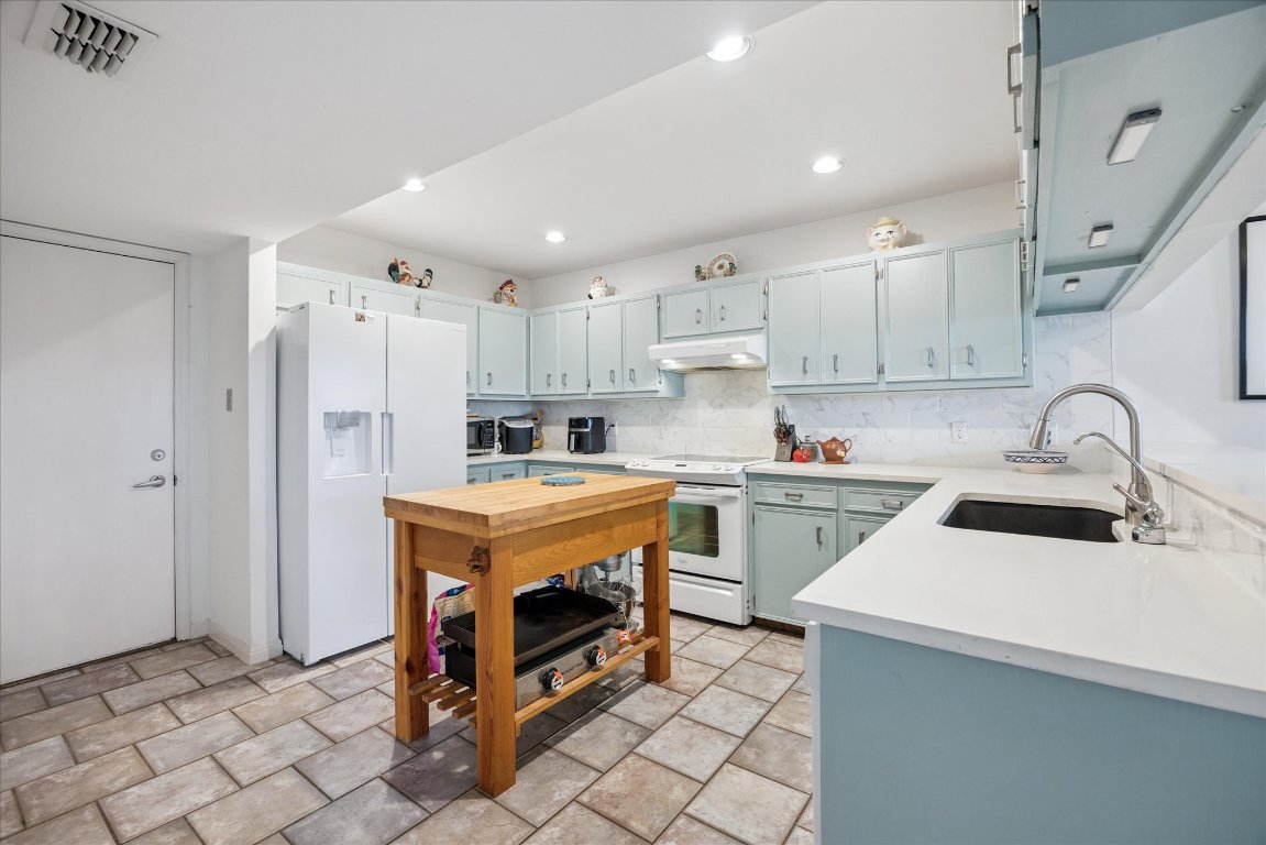 7806 Comanche Trail Leander, TX 78641 - Photo 13 of 32 a kitchen with stainless steel appliances granite countertop a sink stove and refrigerator
