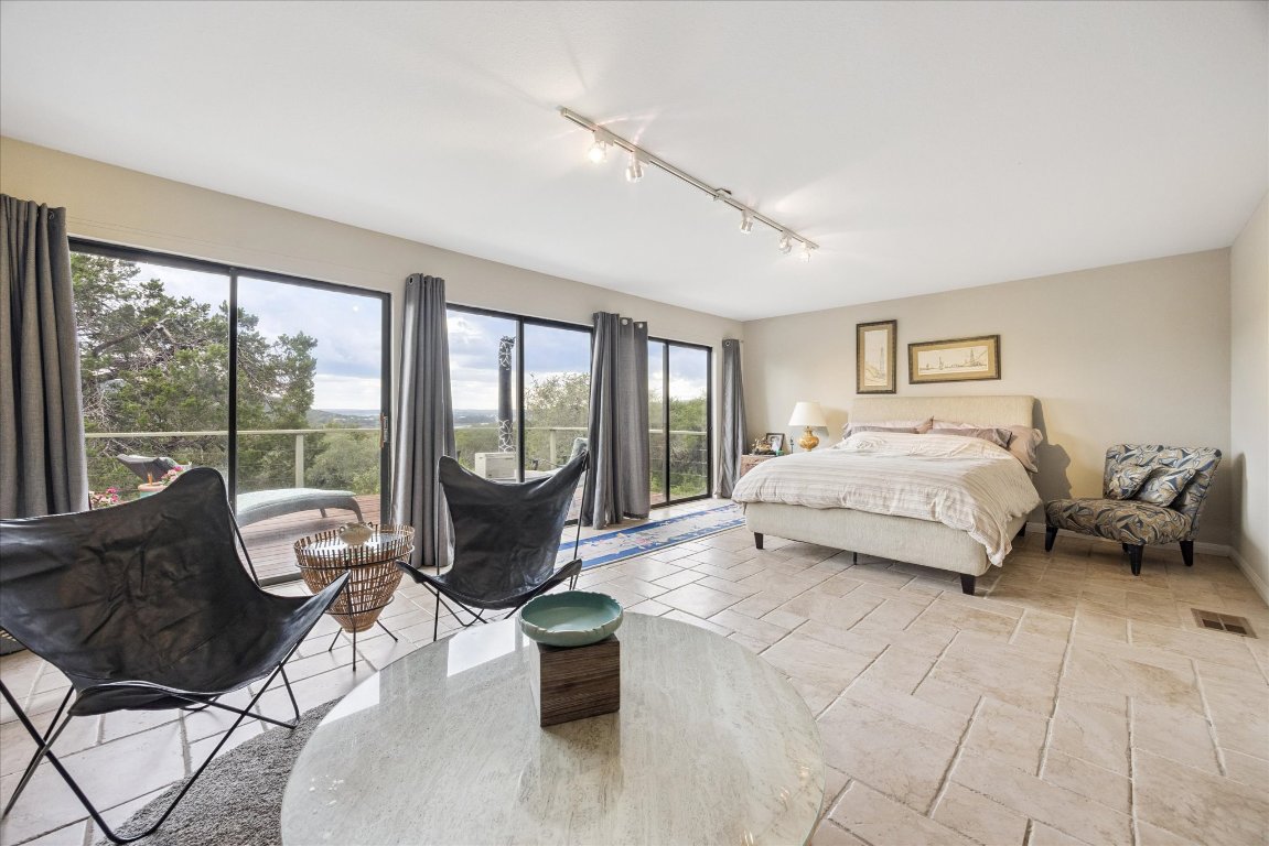 7806 Comanche Trail Leander, TX 78641 - Photo 15 of 32 a spacious bedroom with a bed and glass window