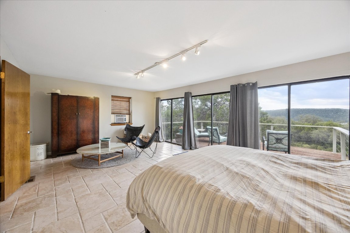 7806 Comanche Trail Leander, TX 78641 - Photo 16 of 32 a bedroom with a bed and large windows