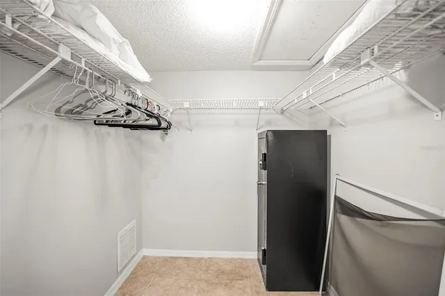 a bedroom with a bed and a lamp on the dresser