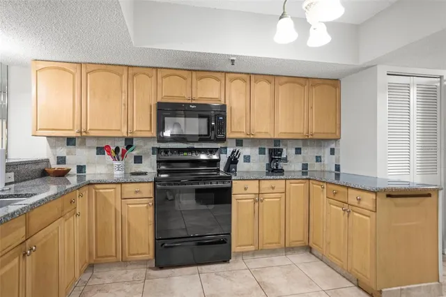 a kitchen with stainless steel appliances granite countertop a sink dishwasher stove and refrigerator