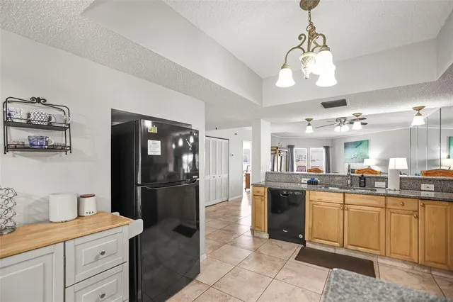 a kitchen with a refrigerator a stove a washer dryer and white cabinets