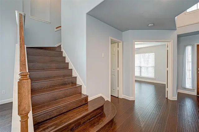 a view of a hallway with wooden floor and entryway