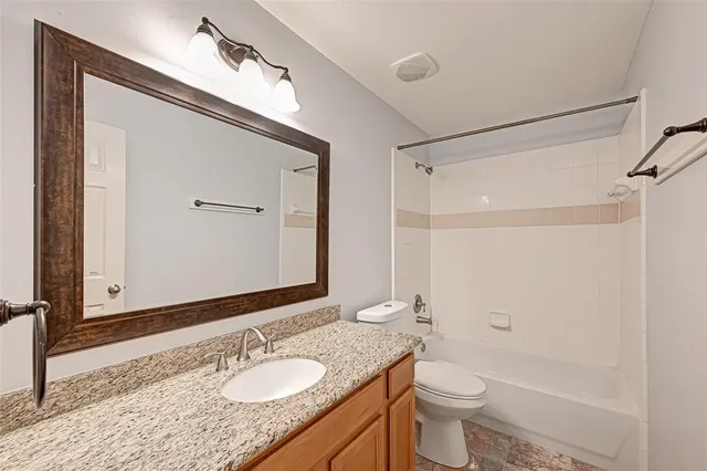 a bathroom with a granite countertop sink toilet and shower