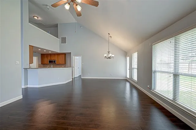 a view of an empty room with wooden floor fireplace and a window