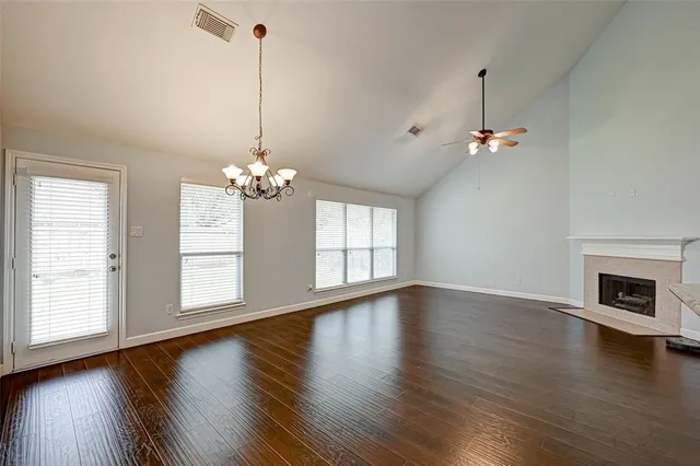 a view of a hallway with wooden floor and windows