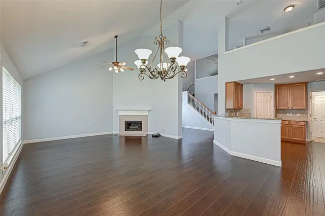 a view of a room with wooden floor and kitchen view