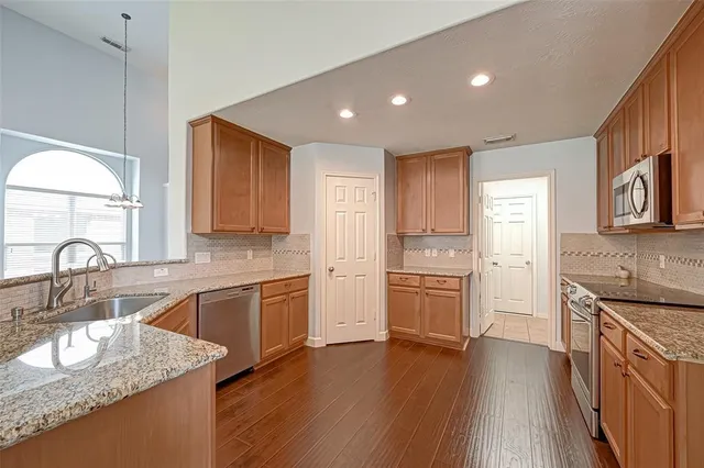 a kitchen with a sink stove top oven and refrigerator
