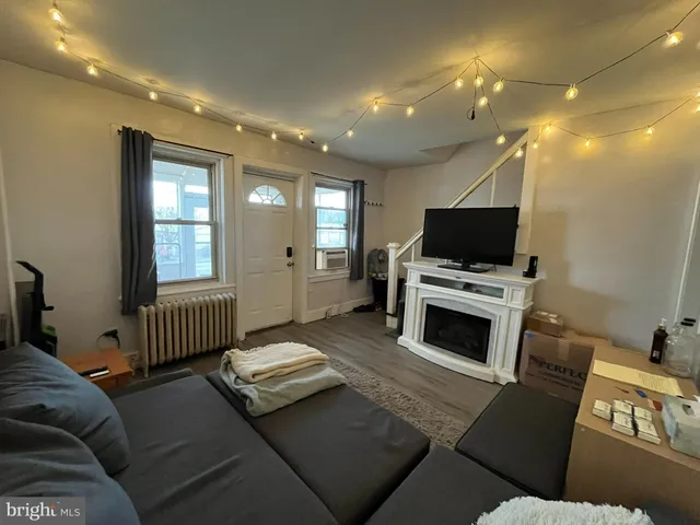 a living room with furniture a flat screen tv and a fireplace