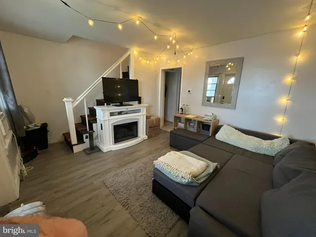 a living room with furniture a flat screen tv and a fireplace