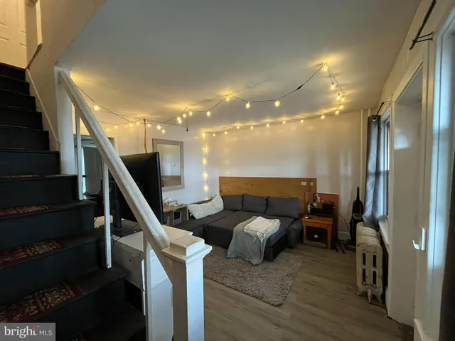 a living room with furniture and stairs