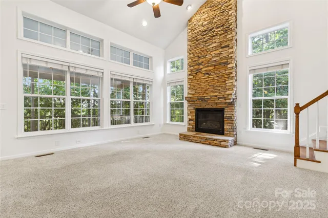 a view of an empty room with a fireplace and windows