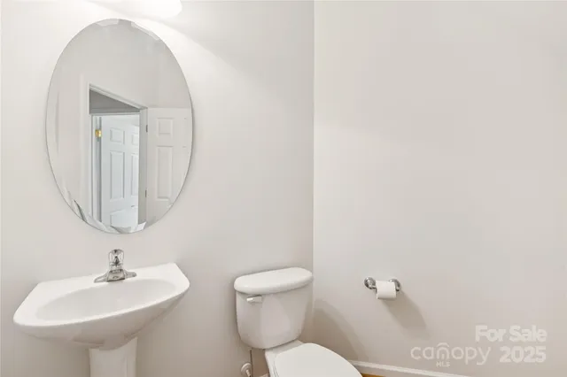 a bathroom with a toilet a sink and a mirror