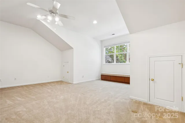 an empty room with windows and ceiling fan