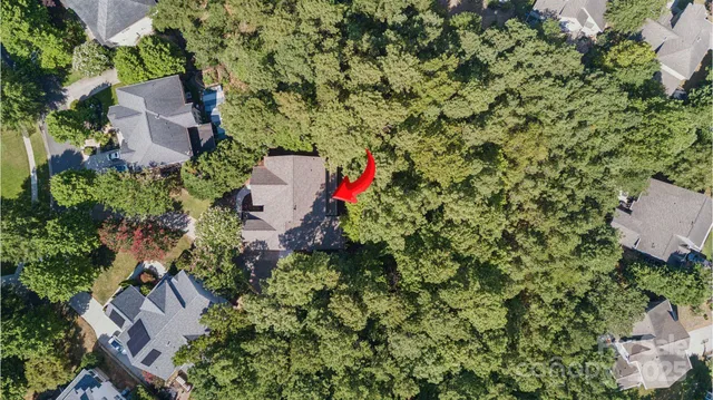 an aerial view of residential house with outdoor space and trees all around
