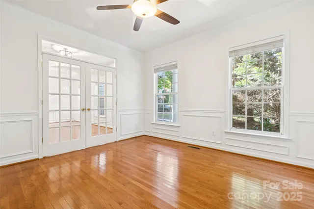 a view of an empty room with a window and wooden floor