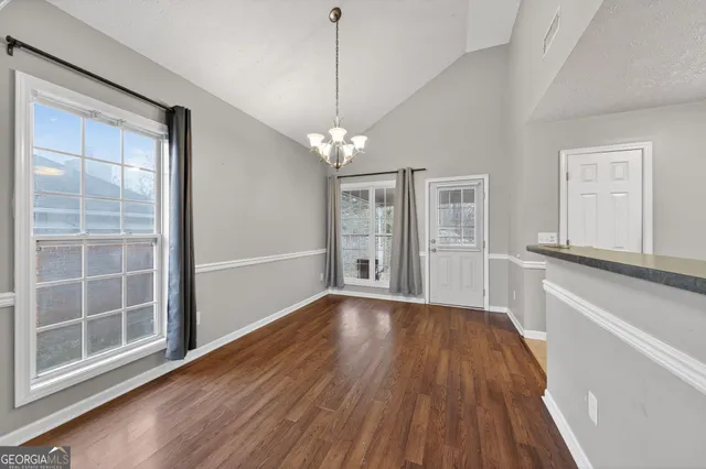 a view of a livingroom with wooden floor and a large window