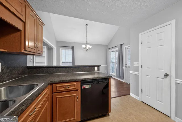 a kitchen with granite countertop a sink and a refrigerator