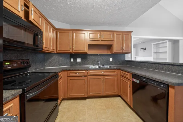 a kitchen with stainless steel appliances granite countertop a sink stove and microwave