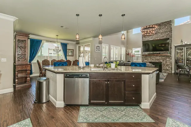 a kitchen with stainless steel appliances granite countertop a sink stove and wooden floor