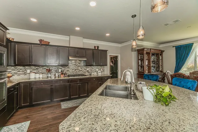 a kitchen with stainless steel appliances granite countertop a sink refrigerator and cabinets