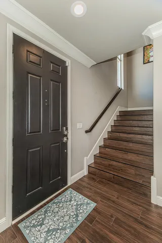 a view of a hallway with wooden floor and a rug