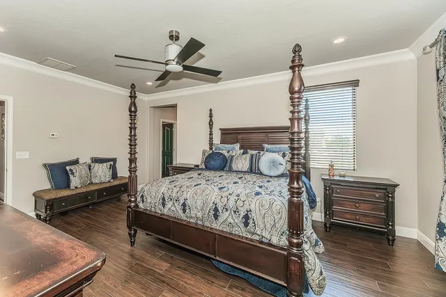 a bedroom with a bed wooden floor and window