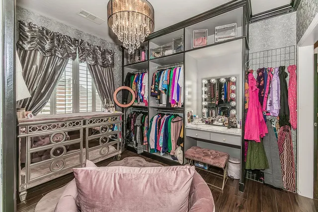 a view of walk in closet with clothes and shoes