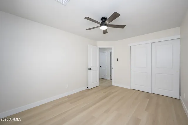 a view of a big room with wooden floor closet and windows
