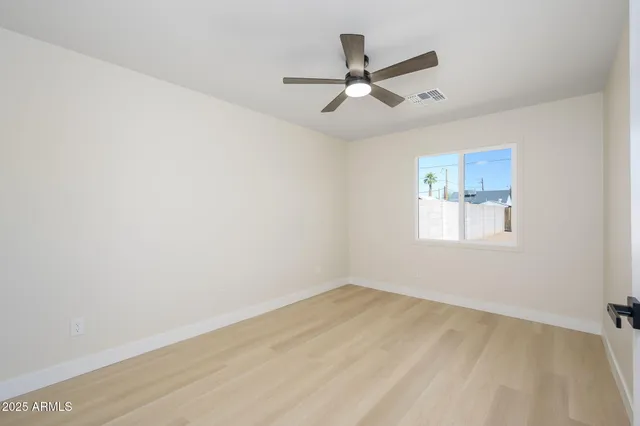 a view of a big room with wooden floor closet and windows in it