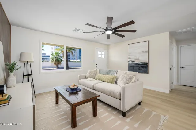 a living room with furniture and a wooden floor