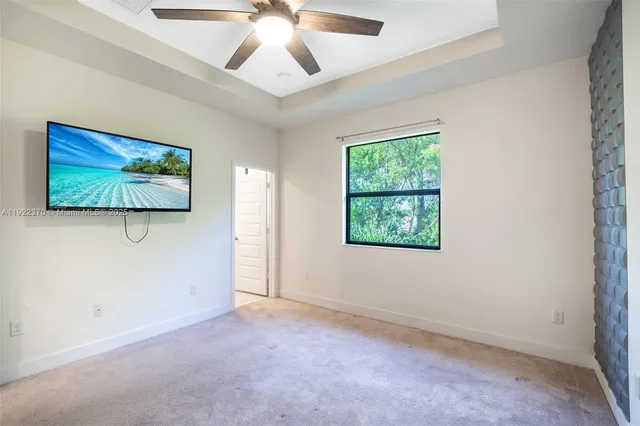 an empty room with windows and ceiling fan
