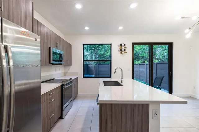 a kitchen with stainless steel appliances granite countertop a sink stove and refrigerator