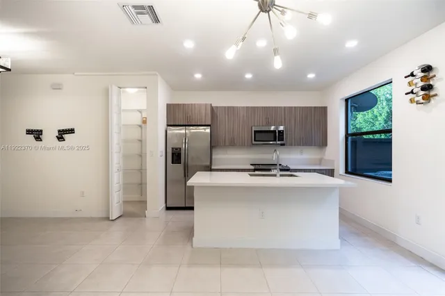 a view of kitchen with stainless steel appliances granite countertop a sink dishwasher stove top oven and refrigerator