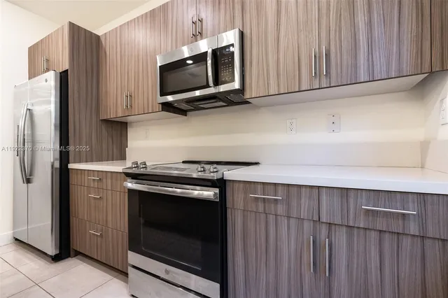 a kitchen with stainless steel appliances a stove microwave and refrigerator