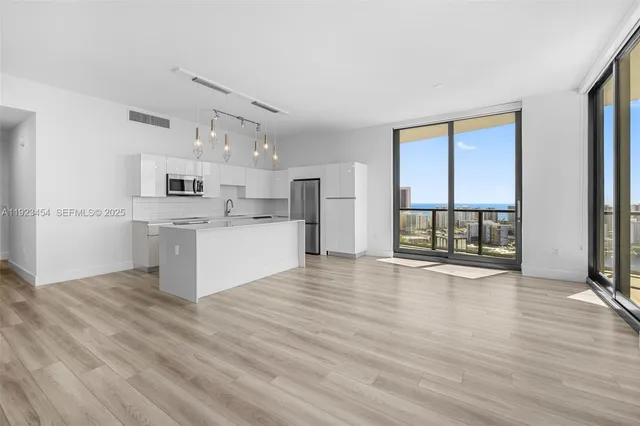 a view of a kitchen with wooden floor and electronic appliances