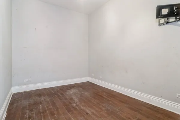 a view of a small space with wooden floor and a window