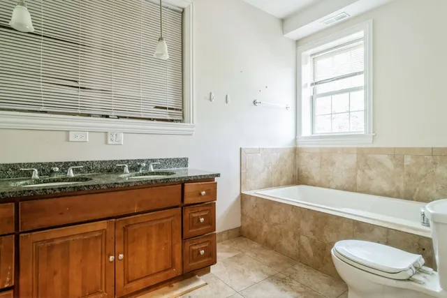 a bathroom with a granite countertop toilet a sink and a bathtub