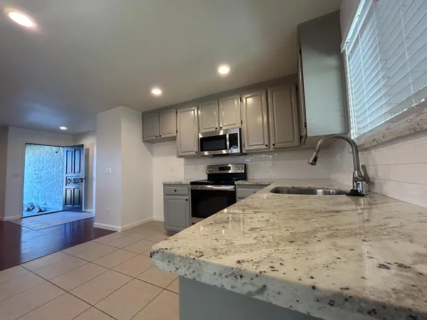 a kitchen with stainless steel appliances granite countertop a sink stove and refrigerator