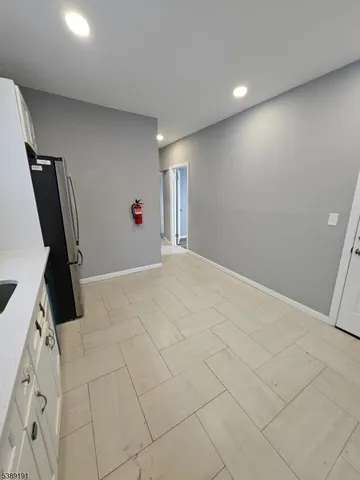 a kitchen with granite countertop a refrigerator and a sink
