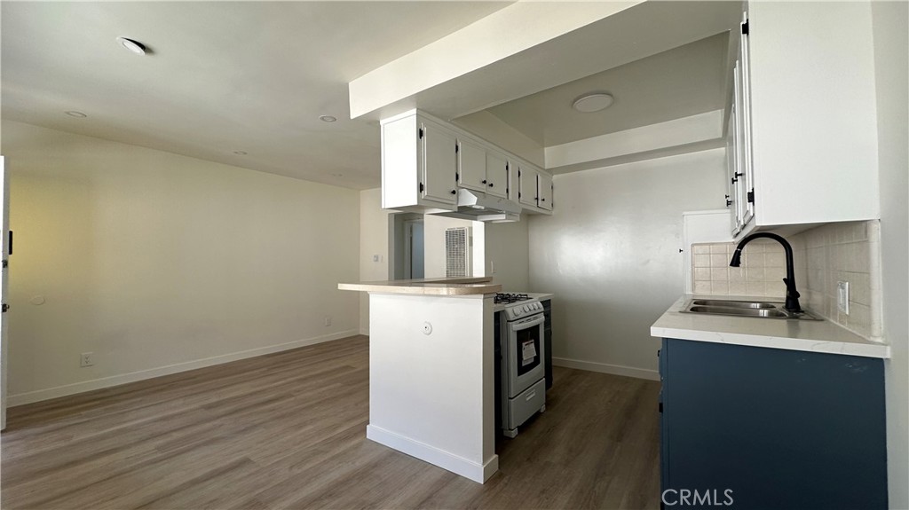 525 Howard Street, Unit E Alhambra, CA 91801 - Photo 2 of 5 a kitchen with stainless steel appliances granite countertop a sink stove and wooden floor