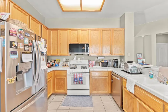 a kitchen with stainless steel appliances a stove sink refrigerator and cabinets