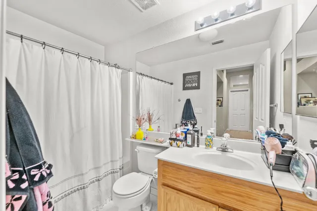 a bathroom with a granite countertop sink a toilet and a mirror