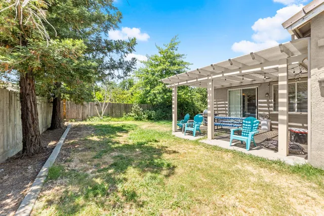 a view of a house with backyard and a large tree