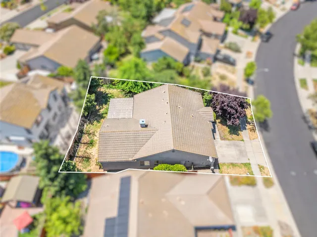 an aerial view of a house with a yard and large trees
