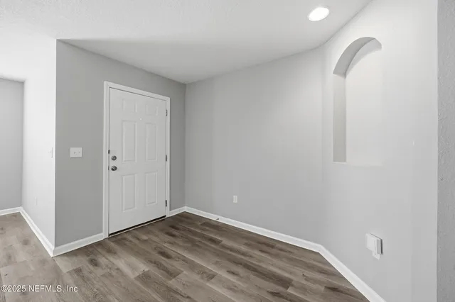 a view of a room with wooden floor and white wall