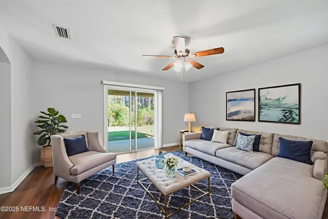 a living room with furniture a rug and a window